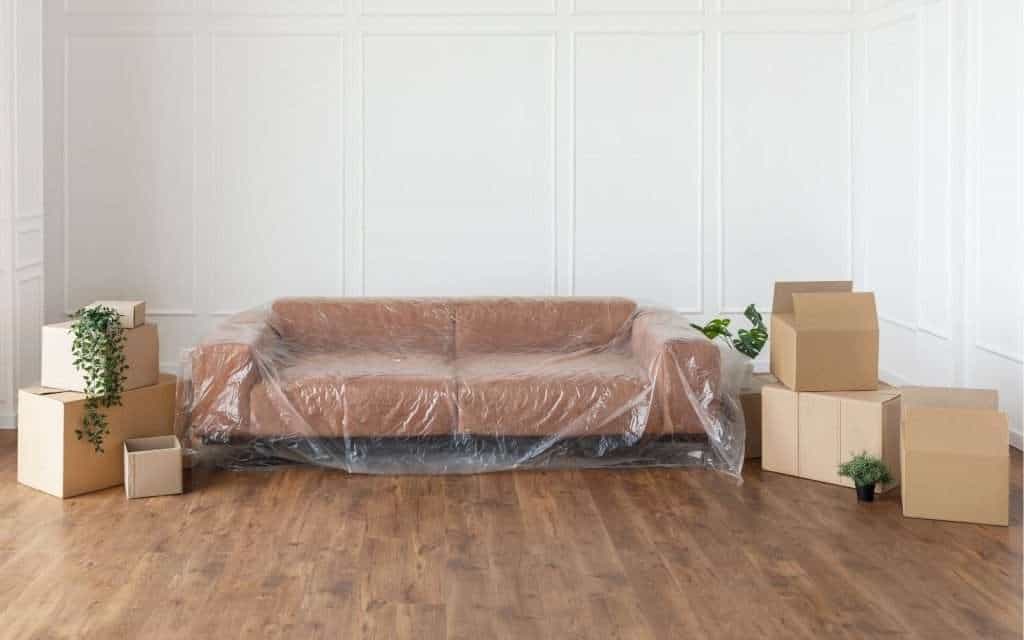 Packed boxes and wrapped furniture from movers in Kitty Hawk in a living room